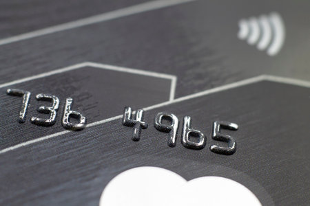 Stack of bank cards. Credit cards. Close-up picture of a credit card as a background. Macro shot, selective focus. Raised numbers on a bank card.の写真素材