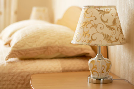 Lamp for reading on a bedside table against the background of a cozy interior of the bedroom. Selective focus.の写真素材