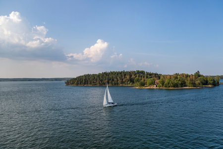 A yacht sailing in skerries near Stockholm.の写真素材