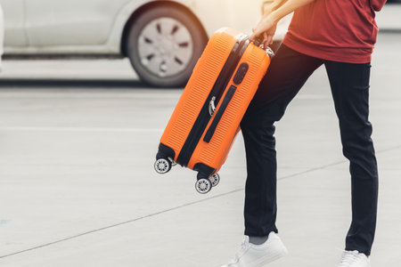 Woman tourist with orange suitcase at station background. travel, tourist, vacation concept.の写真素材