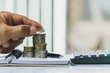 Men are Saint documents about save money  with  some coins calculator  on desk.の写真素材