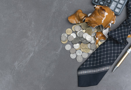 broken piggy with calculator, coins,pen,note concept on table.