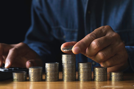 Business man putting  a coin on coins stack saving bank and account for his money all in finance accounting concept.の写真素材