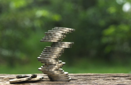 close up the pile of coins on wooden in soft nature background for saving,business,financial concept.の写真素材