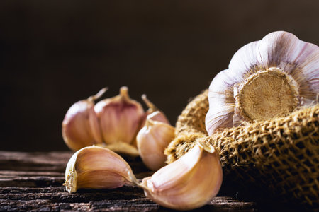Closeup garlic on wooden texture on for cooking on dark backgroundの写真素材