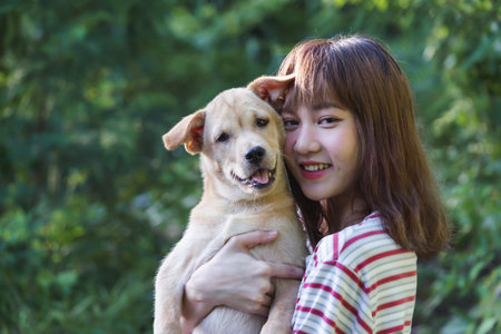 Portrait girl hug with her puppy on nature background.