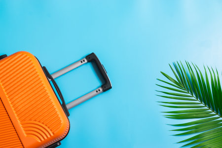 Flat lay orange suitcase with traveler accessories on soft blue background. travel, summer and holiday concept