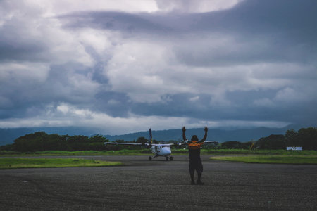 Man directing aircraft at Honiara airportのeditorial素材