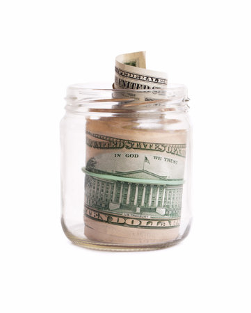Glass pot with dollars on the white backgroundの写真素材