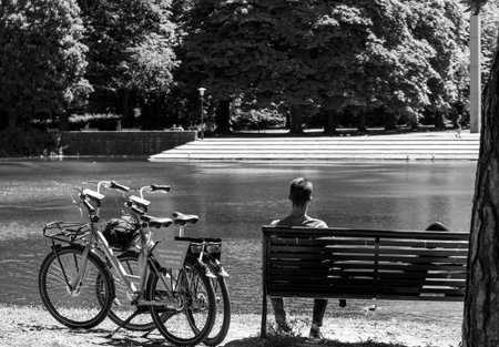 A couple resting at a bench on Sweden national day after going to the park by using a rental bike from Donkey Republic.のeditorial素材