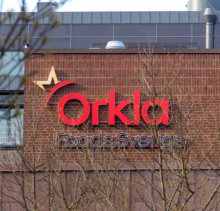 The logo of Orkla Foods Sverige mounted on a brown brick building in VÃ¤stra hamnen, MalmÃ¶, Sweden.のeditorial素材