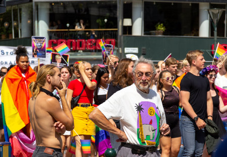 MalmÃ¶, Sweden - July 20, 2019: An old man and a younger bare chested man both have a troubled look as they participate in the gay pride parade through the citycenter of MalmÃ¶, Sweden.のeditorial素材