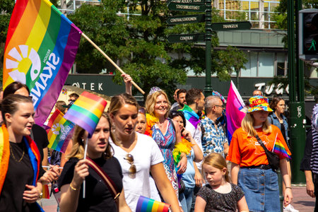 MalmÃ¶, Sweden - July 20, 2019: The head of development within Region SkÃ¥ne, Ulrika Geeraedts, is marching in the pride parade, waving a rainbow flag during the annual pride parade in MalmÃ¶, Sweden.のeditorial素材