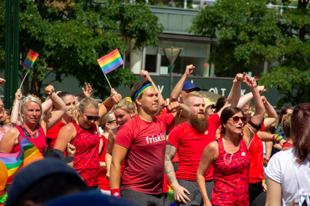MalmÃ¶, Sweden - July 20, 2019: People dressed in red gym wear, fist pumping to the rhythm of the music, as they participate in the annual gay pride parade in downtown MalmÃ¶, Sweden.のeditorial素材