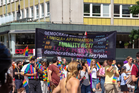 MalmÃ¶, Sweden - July 20, 2019: People holding up a banner from Democrats Abroad with messages about love and equality during the annual gay pride parade in MalmÃ¶, Sweden.のeditorial素材