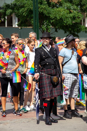 MalmÃ¶, Sweden - July 20, 2019: An eccentric man dressed in a Scottish way with kilt and a bowler hat amongst other accessories, as he is taking part in the annual gay pride parade.のeditorial素材