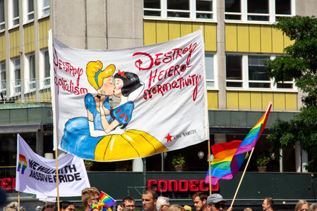 MalmÃ¶, Sweden - July 20, 2019: Left wing people are carrying a banner with Cinderella and Snow White kissing during the annual pride parade in MalmÃ¶, Sweden.のeditorial素材