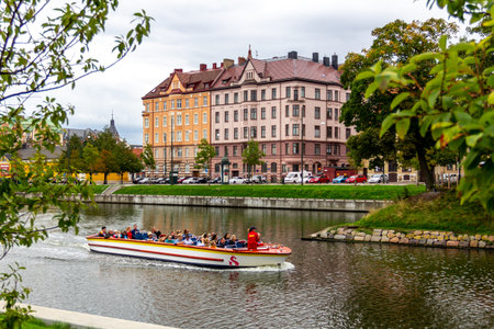 MalmÃ¶, Sweden - September 2, 2018: The sightseeing boat Rundan is half full with tourists as the guide informs them about parks and old buildings along the canalのeditorial素材