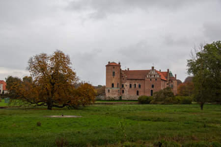 Torup, Sweden - October 20, 2019: The red brick castle Torup still stands on the green field in the castle gardens on an overcast autumn dayのeditorial素材