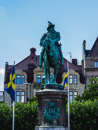 MalmÃ¶, Sweden - July 11, 2018: A grand statue on the town square stands proud. With the Swedish flags in background, it gives a patriotic impression.のeditorial素材