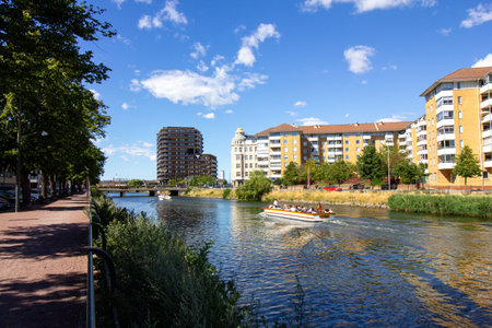 MalmÃ¶, Sweden - July 1, 2018: A boat filled with tourists floats through the canals of the city on a warm summer day with blue skiesのeditorial素材