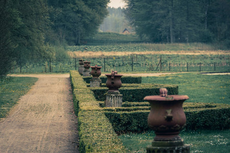 Old urns on pillars in an abandoned garden in the countryside. Sense of loneliness or solitude.