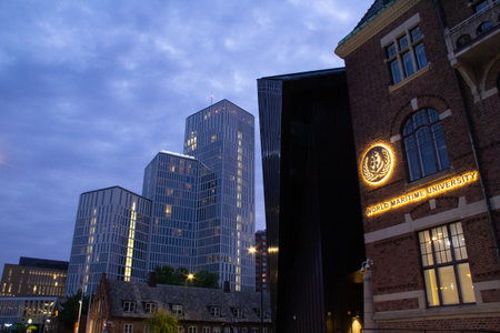 MalmÃ¶, Sweden - May 20, 2019: The World Maritime University logo is lit up on the facade of their building close to MalmÃ¶ Live, some skyscrapers in the background holding a hotel and congress centerのeditorial素材