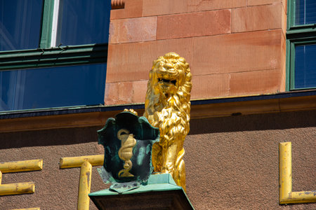 MalmÃ¶, Sweden - July 11, 2018: This golden lion sculpture is placed on the facade of the very old pharmacy called Apoteket Lejonet (The Lion's pharmacy)のeditorial素材