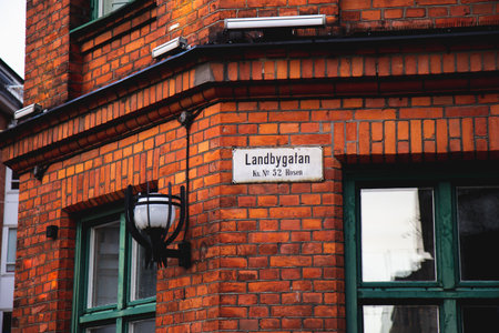 A street sign with the name Landbygatan is mounted on a red brick facade on an old building in the old town of MalmÃ¶, Swedenの写真素材