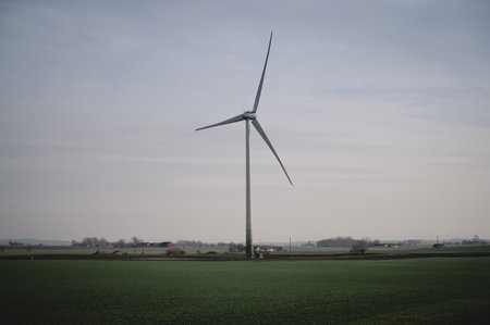 A single wind turbine stands tall above the flat farmlands of SkÃ¥ne, Sweden