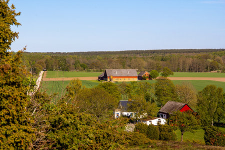 Some farm buildings scattered in the overall flat Scanian landscape in southern Swedenの写真素材
