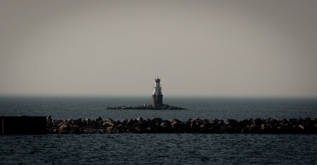 A small automatic lighthouse just outside the city of MalmÃ¶, Sweden, on a dark foggy dayの写真素材
