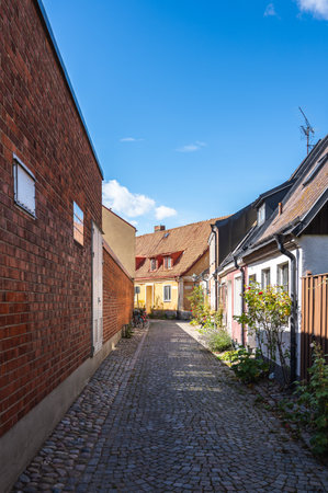 An empty cozy cobblestoned street with town houses and cottages in the village of Ystad, Swedenの写真素材