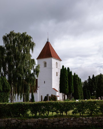 The exterior of Torna-HÃ¤llestad church in a rural setting during summerの写真素材