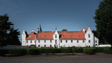 The white facade and orange roof of the medieval BosjÃ¶kloster castle on a bright summer day in Swedenのeditorial素材