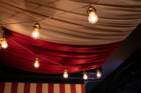 Ceiling decorated with heavy fabrics and light bulbs to show a circus feelingの写真素材
