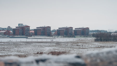 Some red residential highrise buildings in front of the lake RÃ¥bysjÃ¶n in Lund Sweden on a cold snowy dayのeditorial素材
