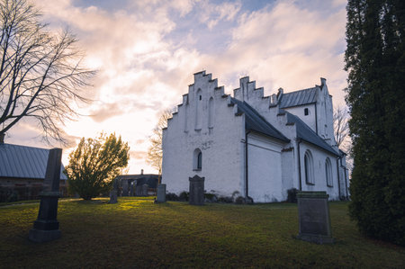 The small medieval church Stora RÃ¥by in a small village outside Lund in Sweden during winter sunsetのeditorial素材
