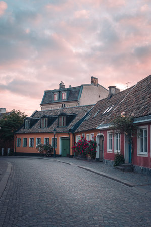 Cobblestoned street and colorful houses in old town Lund Sweden during summer sunsetの写真素材