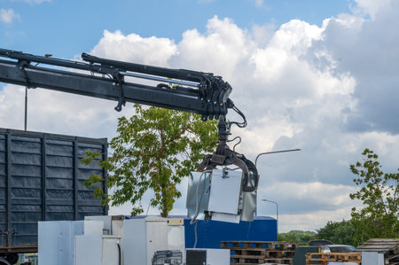 A crane lifting old appliances to bring them to recycling the environment friendly wayの写真素材