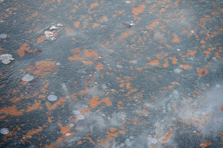 Water frozen to ice texture with bubbles and rusty patchesの写真素材