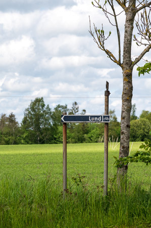 Arrow sign direction to Lund Sweden in rural farmland settingの写真素材