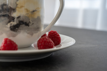 Raspberries on a plate next to coffe cup as part of healthy eating