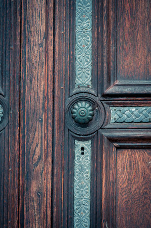 Green door knob handle on historic oak door with keyhole and ornate detailsの写真素材