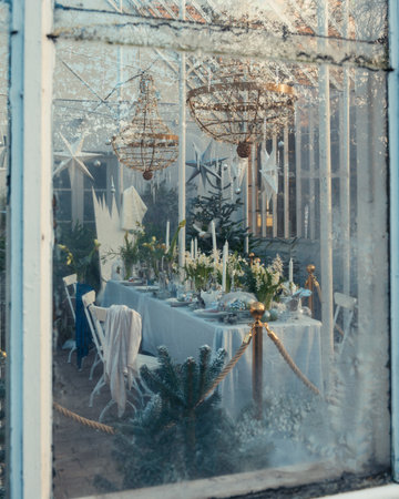 A table set with winter and christmas decor placed in a garden houseの写真素材