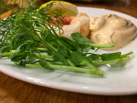 Fresh and health greens with sauce on a white plateの写真素材