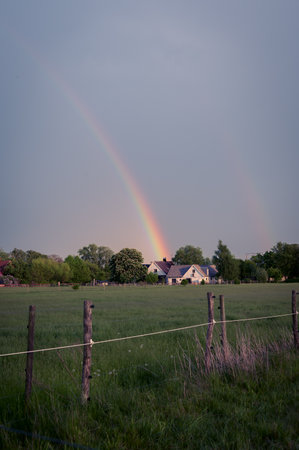 Rainbow ending at rural house in the countryside in SkÃ¥ne (Scania) Swedenの写真素材