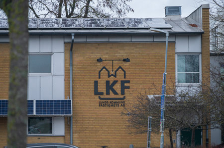 Lund, Sweden - January 14, 2023: The logo of a apartment rental company Lunds kommunala fastighets AB mounted on a yellow brick wallのeditorial素材
