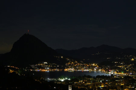 Lugano by night, city urban setting from the air outlining the Monte San Salvatore, Paradiso and the Lake Ceresioの写真素材
