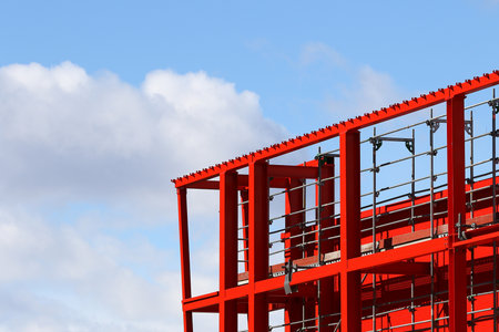 New steel beam construction being built against blue skies and white cloudsの写真素材